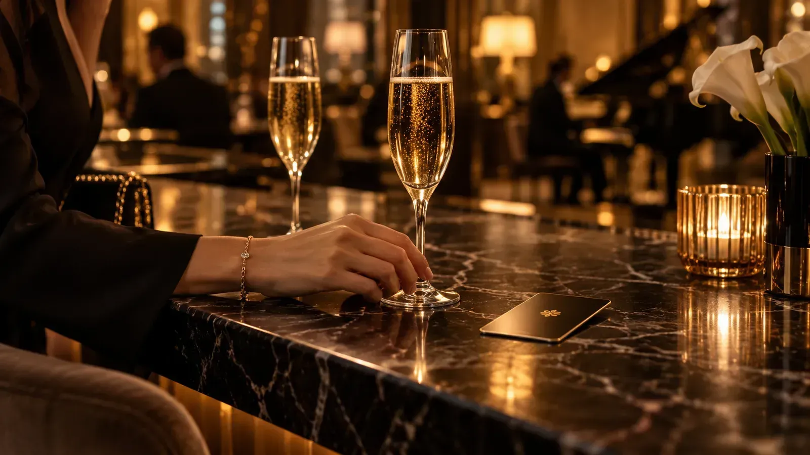 Zwei Champagnergläser und ein Hotelschlüssel auf einer Bar im warmen Abendlicht