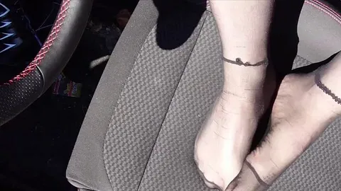 Füße von Nylonjunge in Strumpfhose im Auto